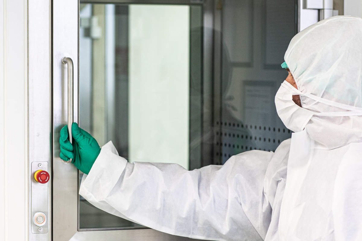 Technician opening door to lab equipment